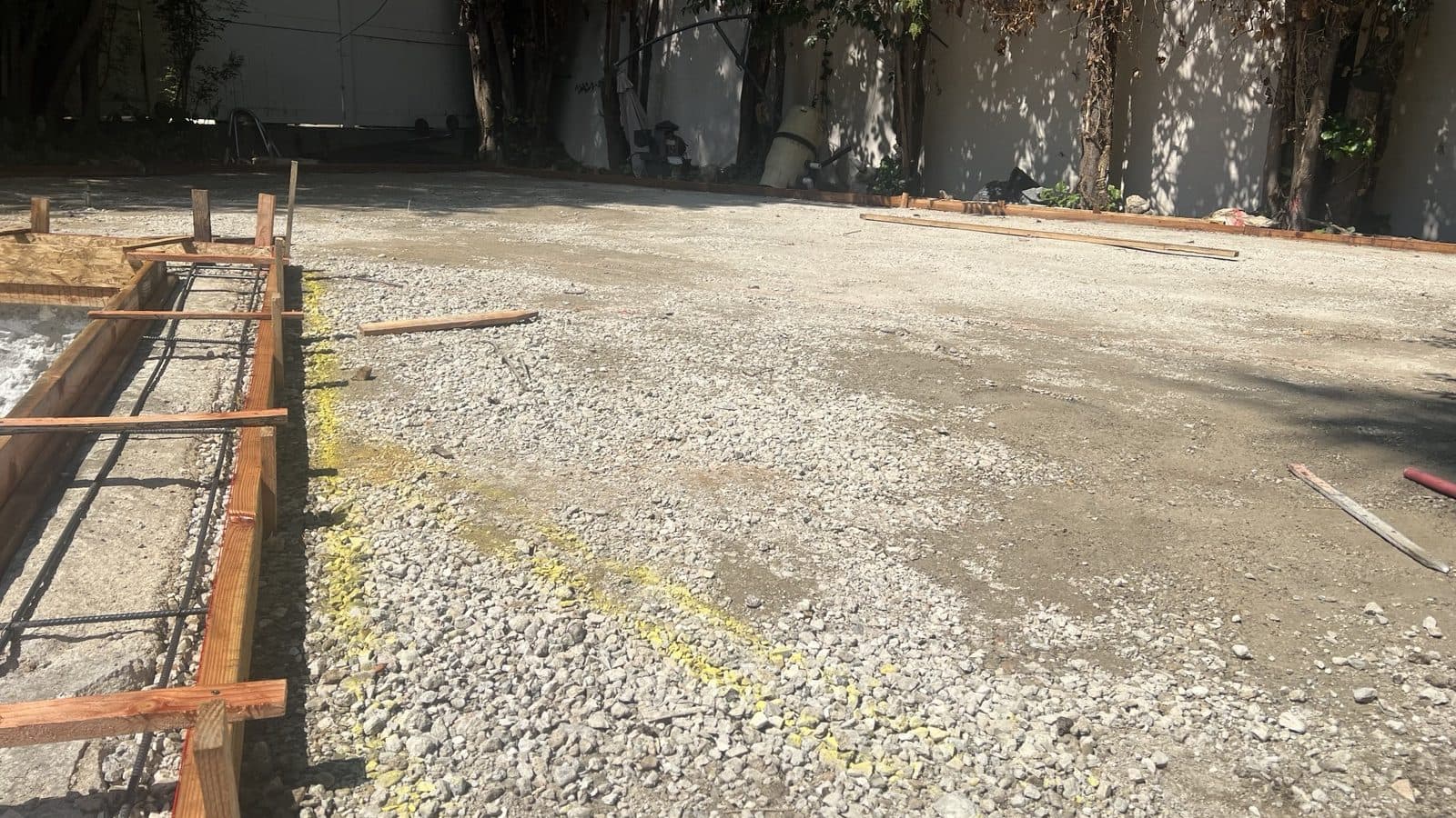 Cleared construction site with the old pool removed and the ground prepared for a new foundation